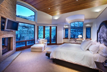 A large bedroom with a view of the mountains.